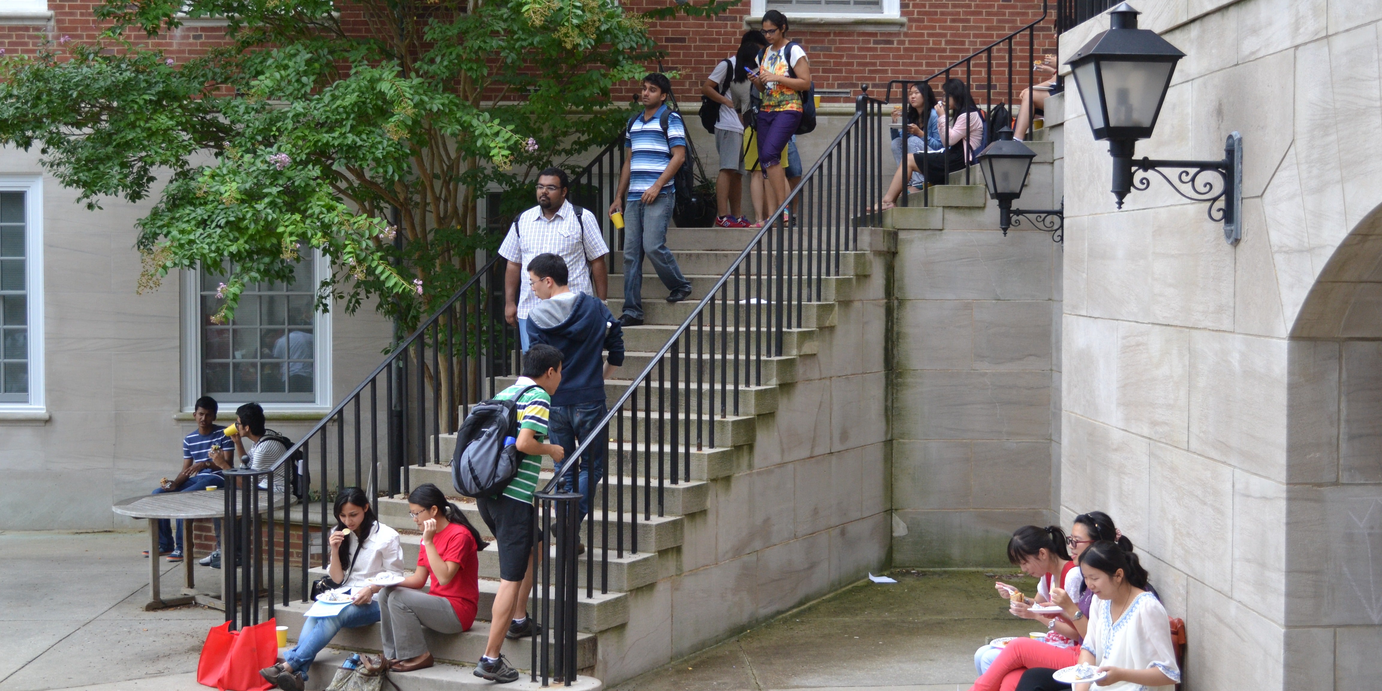 International students sit on stairs.