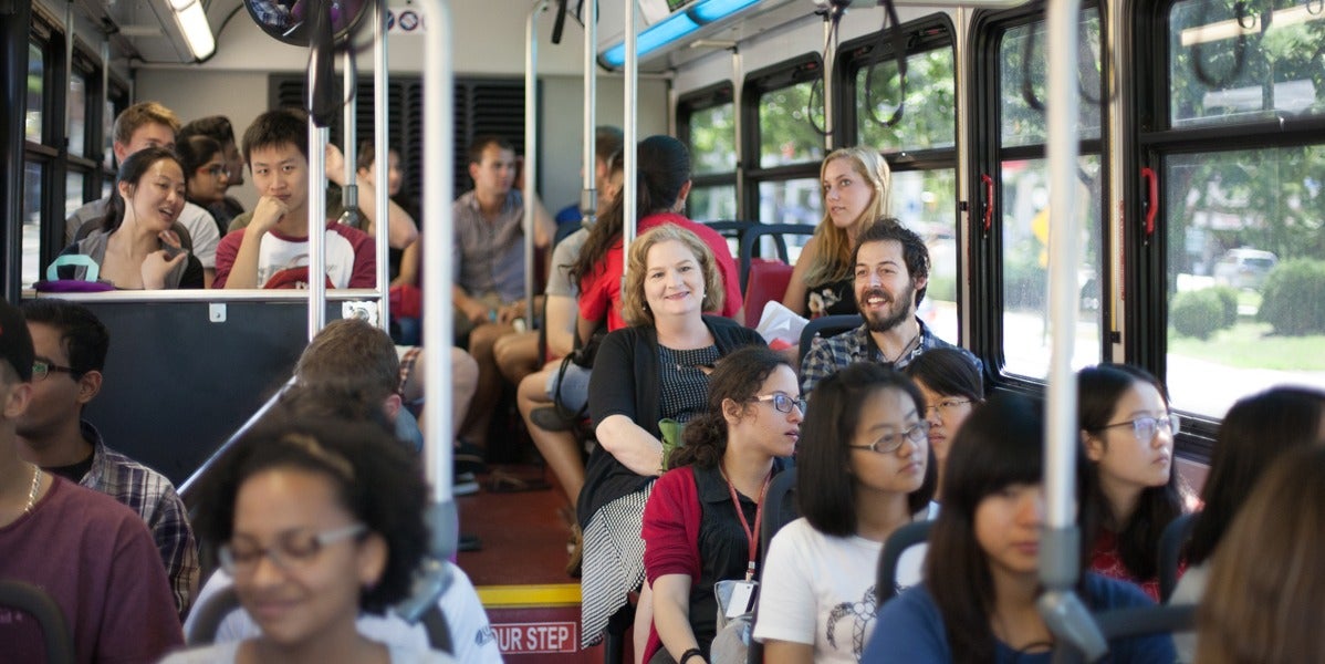 ISSS Associate Director Jody-Heckman Bose sits on a bus with other international students.