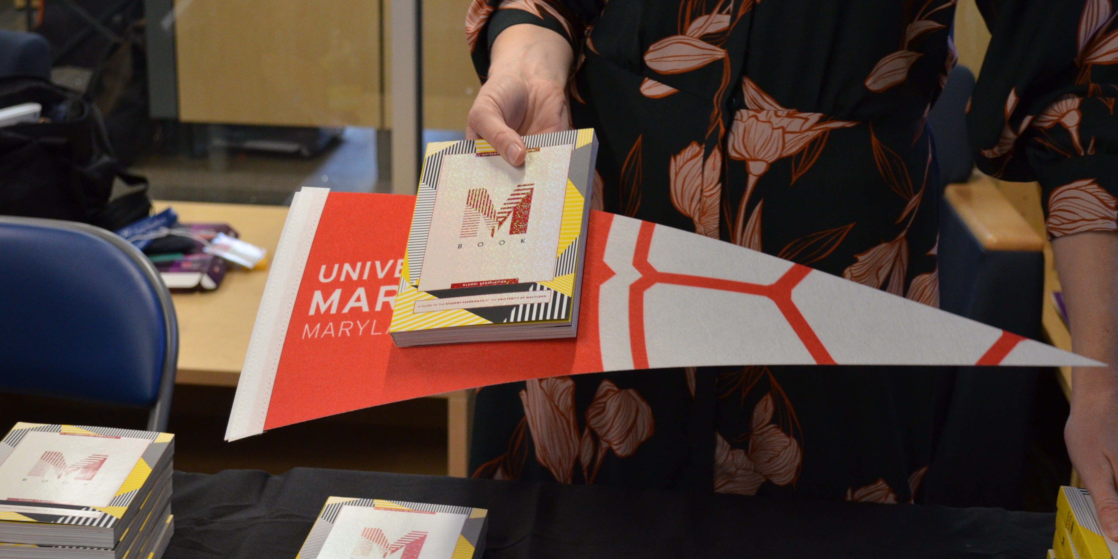 Carly Jimeson hands over a Maryland flag and book.