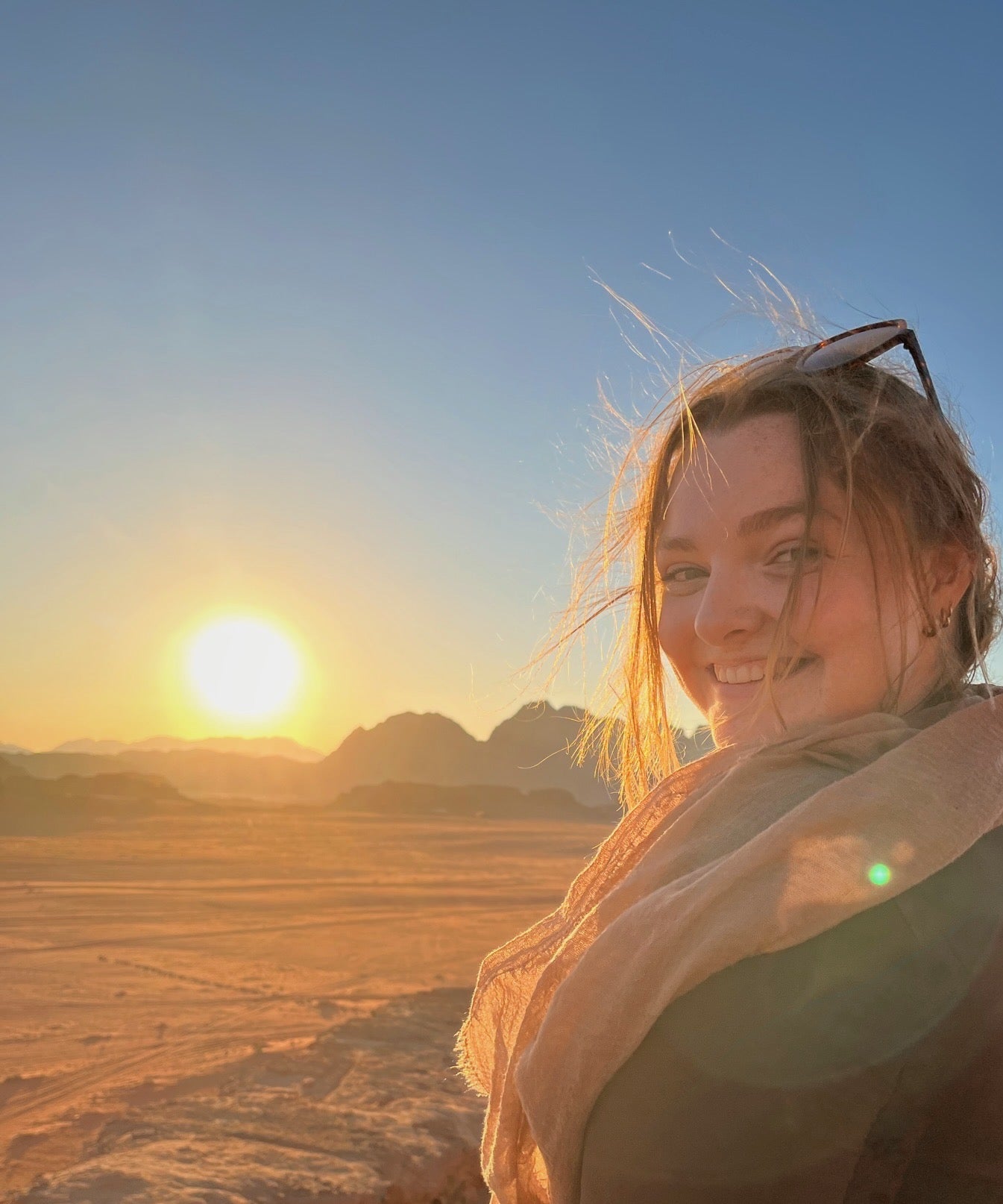 Girl stands on the sand dunes of the desert
