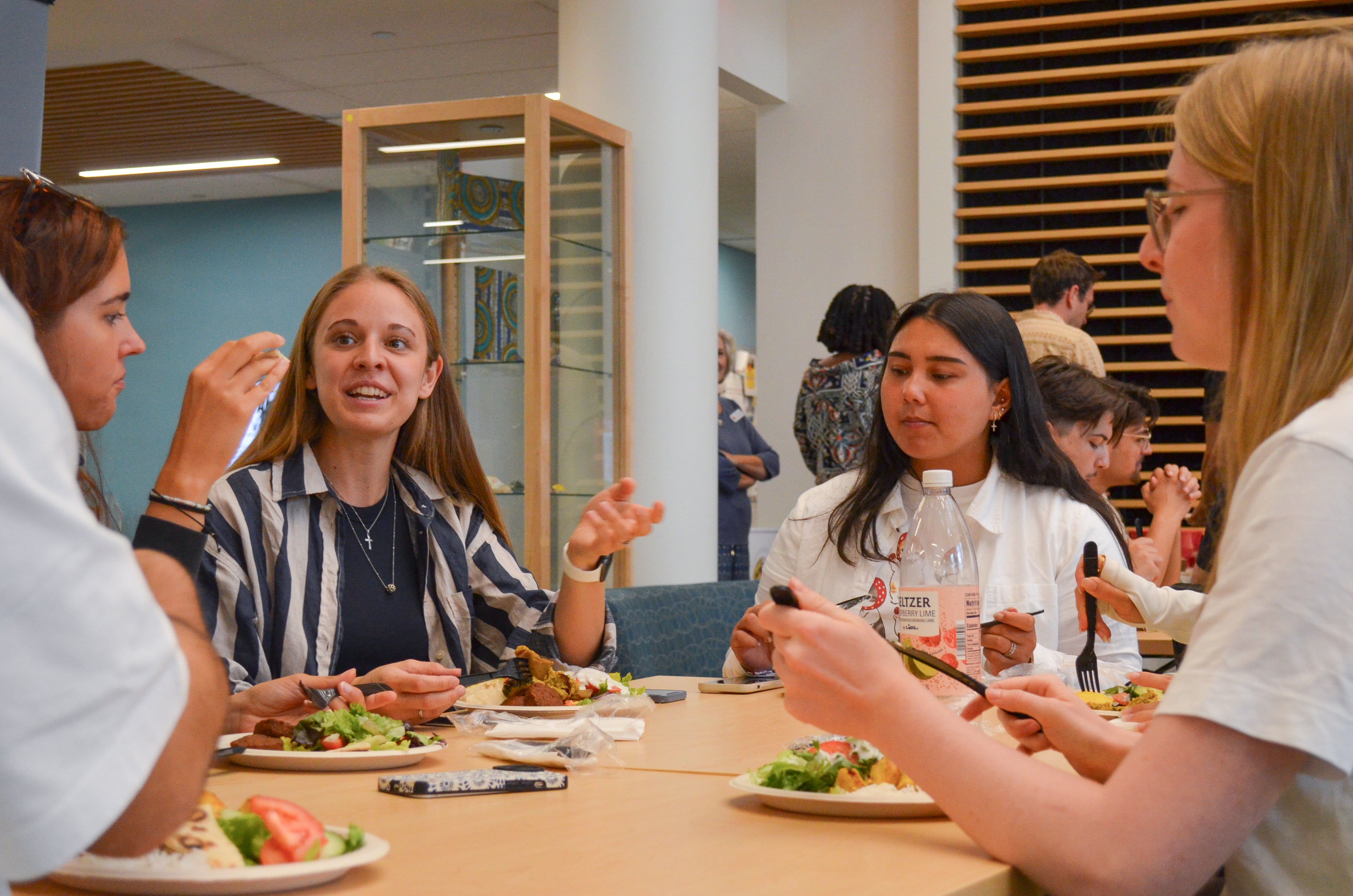 Young women eating lunch around a table