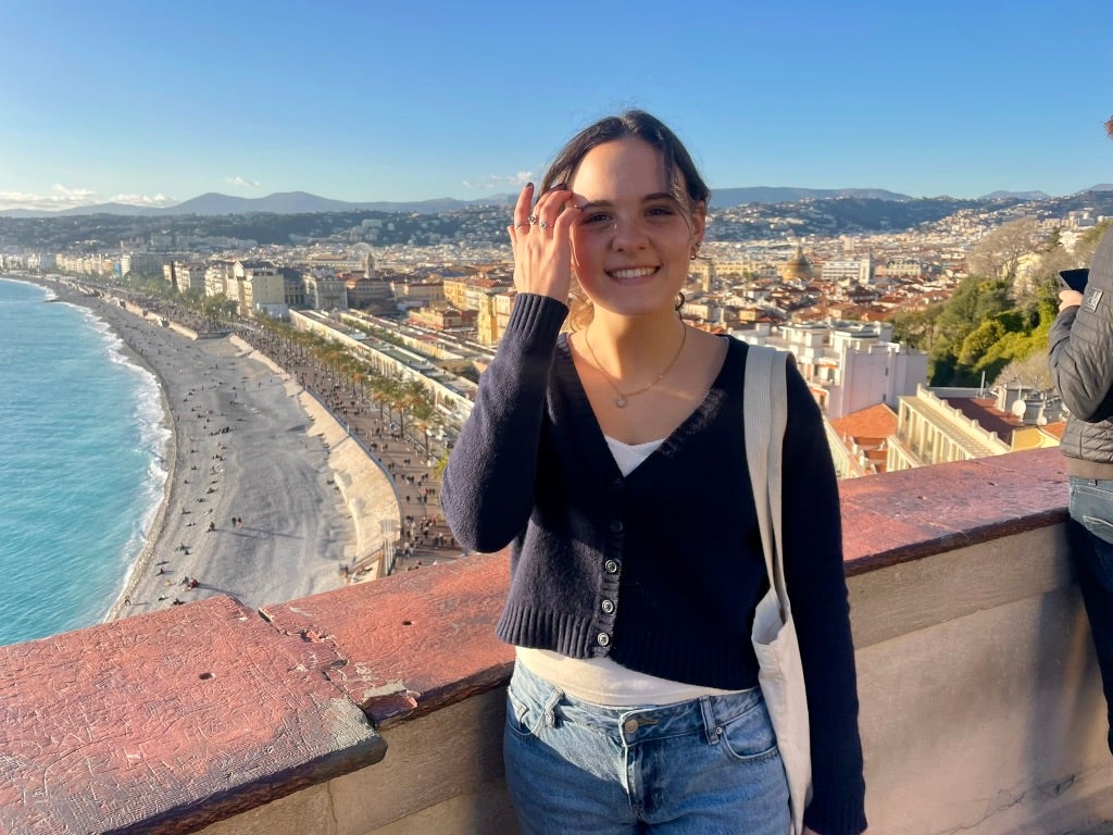 Student Assistant Elle is on a rooftop overlooking the beach in France