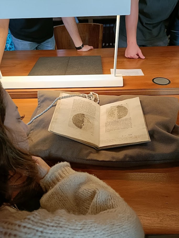 Student studies original manuscripts of Galileo Galilei laid open on a pillow