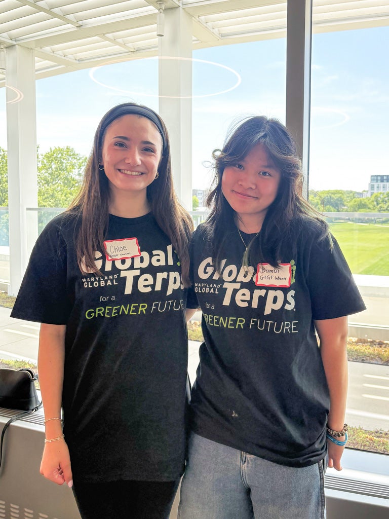Two women wearing Global Terps for a Greener Future shirts stand side-by-side