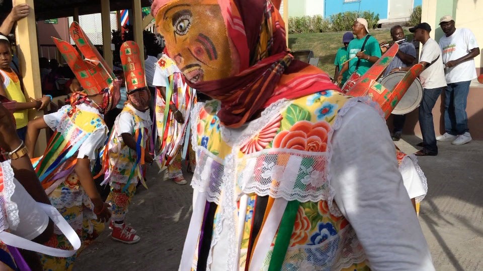 Frevo performers wearing colorful traditional clothing and masks