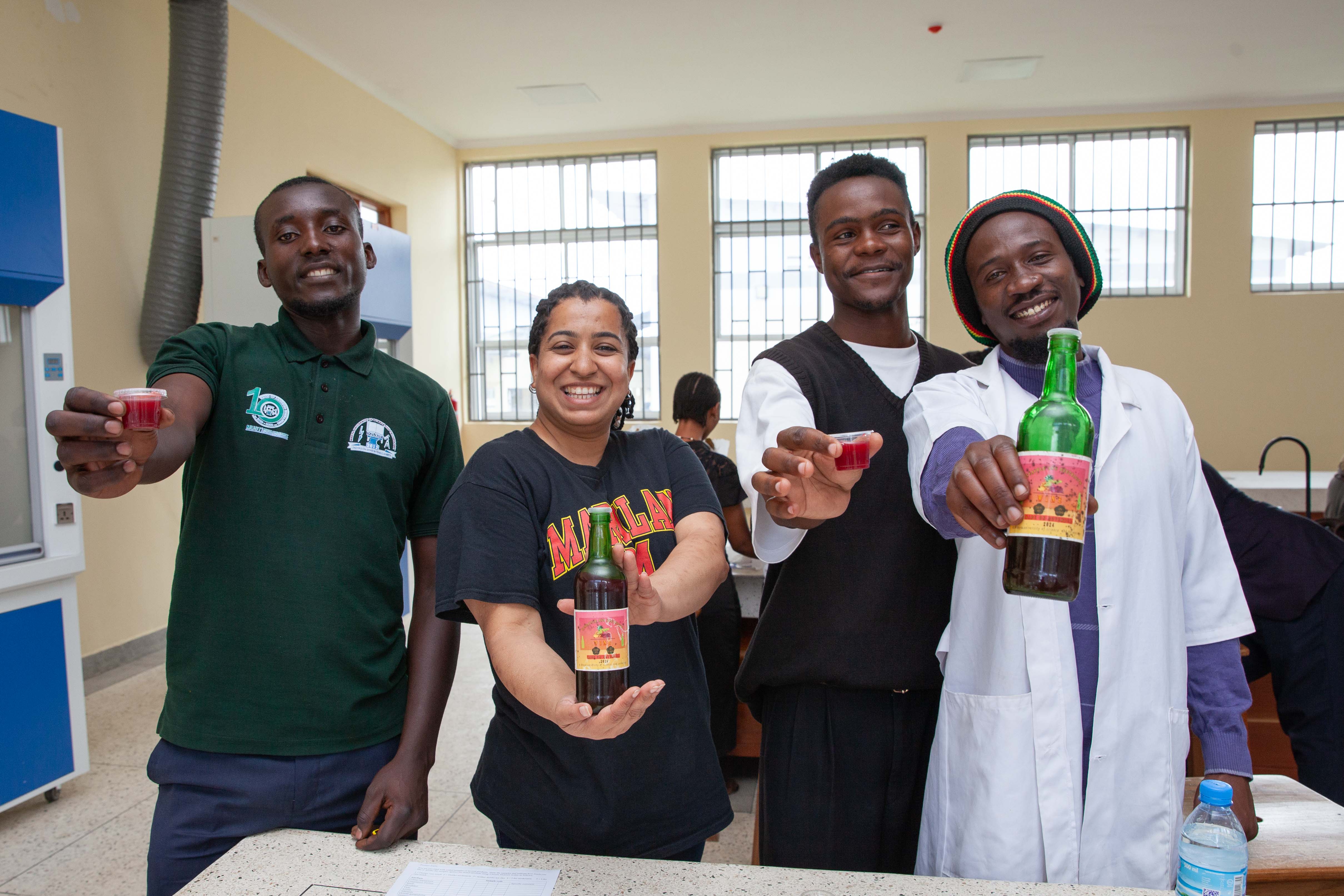 Aishwarya Rao with MUST students showing their beet and pineapple wine.