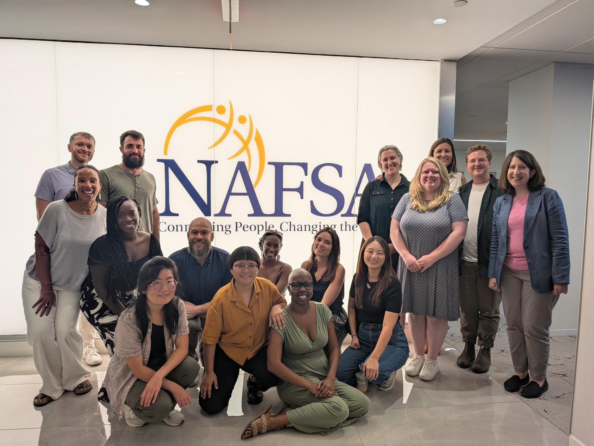 Education Abroad staff gather around a NAFSA sign
