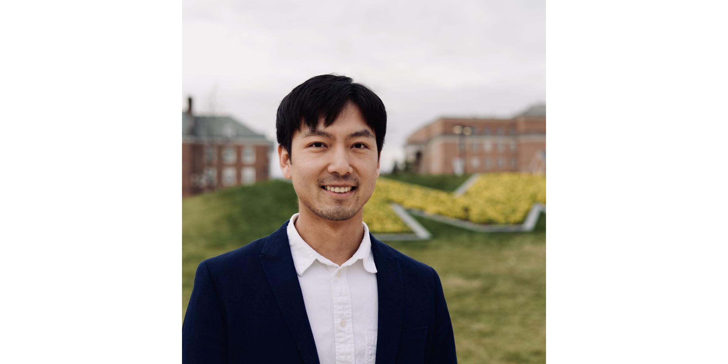 Xinyu Zhai, Language Partner Program coordinator, poses in front of the Maryland 'M'. 