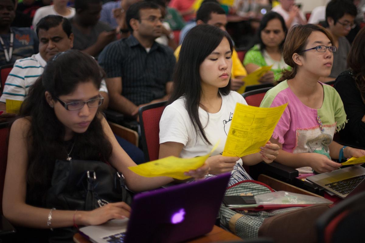 Students sit together in an auditorium. 