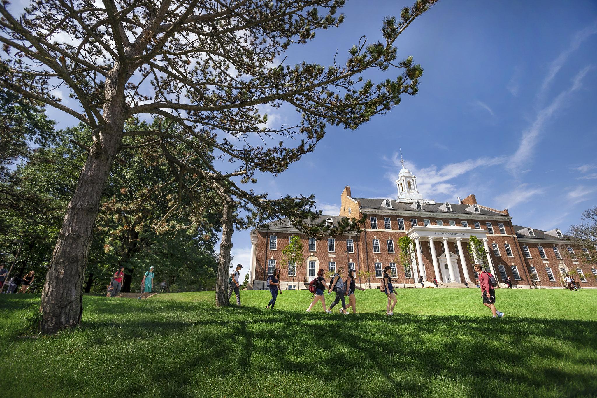 Students walking outdoors with H.J. Patterson Hall in the background.