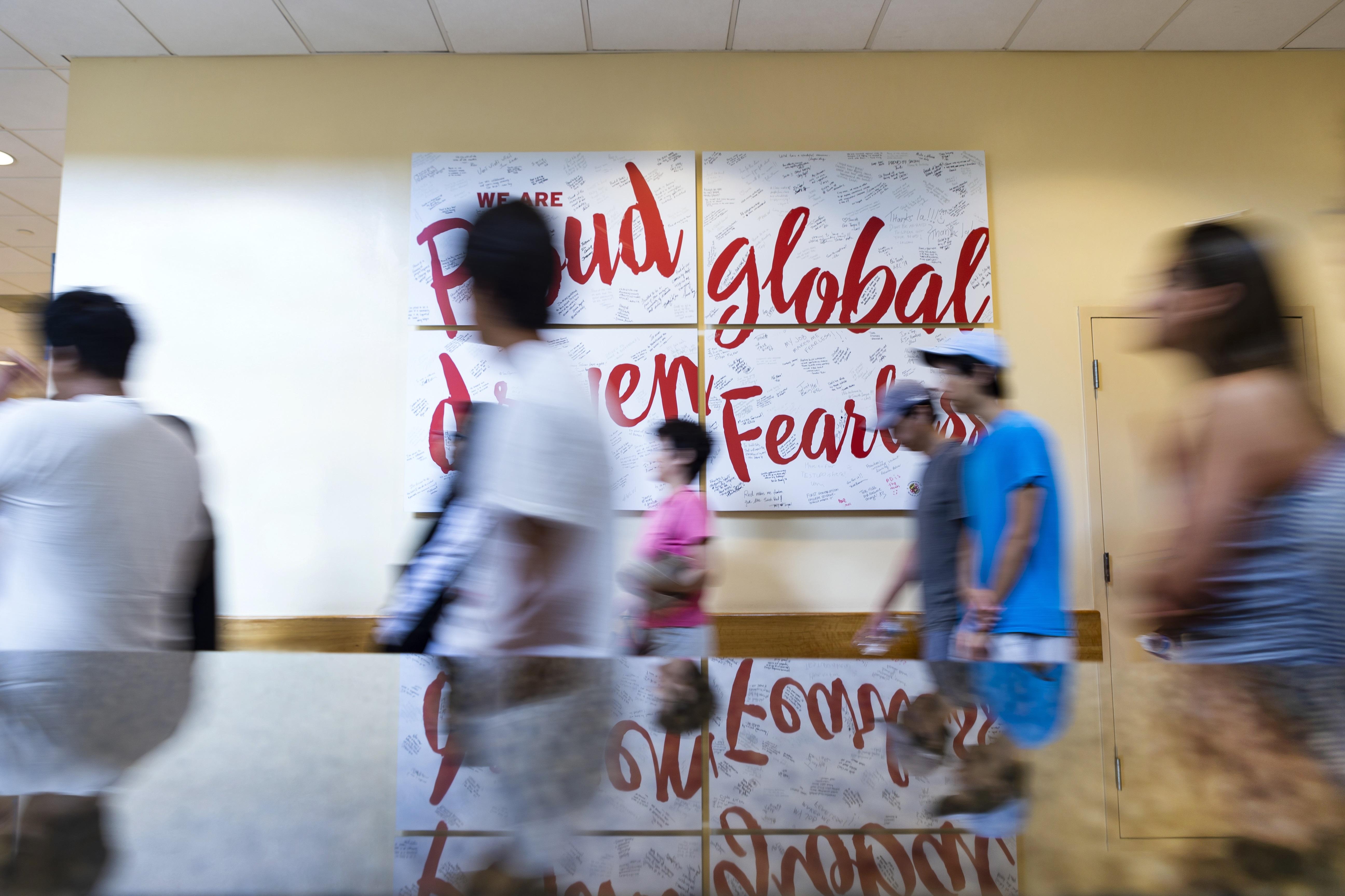 Students walk past "Fearless" art piece.