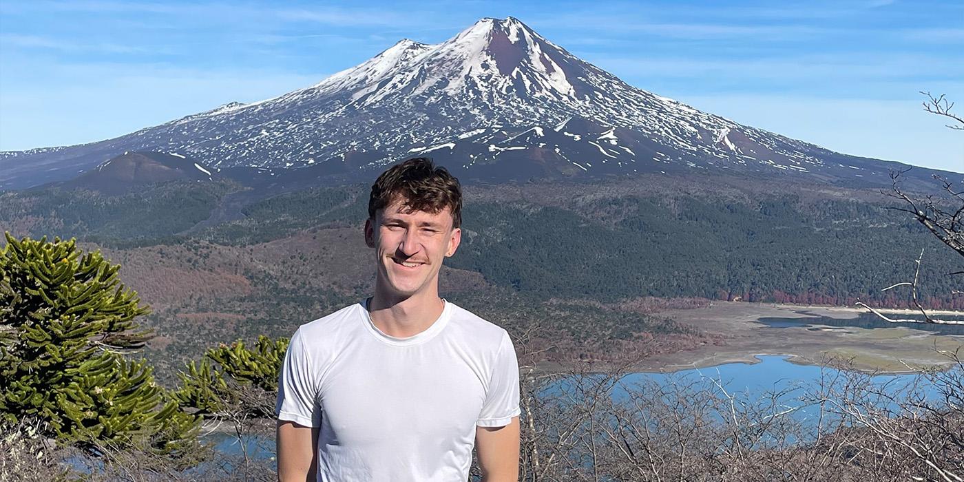 Aidan Goldenberg-Hart standing in Santiago, Chile with mountains in the far distance