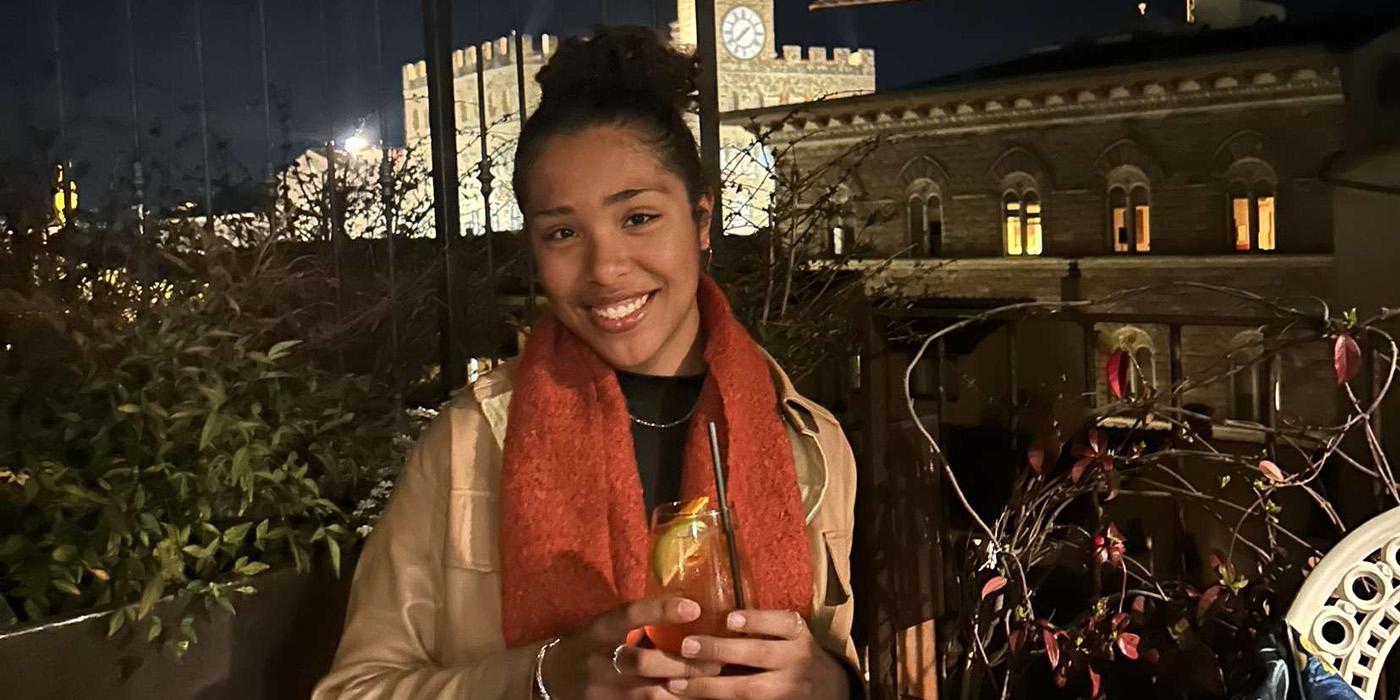 Antoinette Uzamere smiles while holding a drink at an Italian restaurant at night