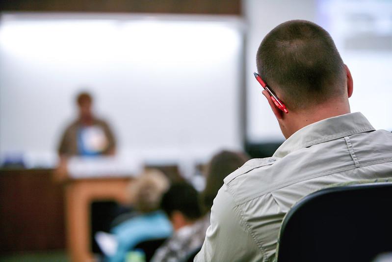 A student in a classroom, looking at the professor.