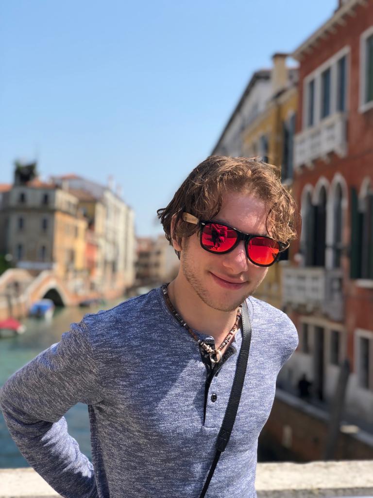 Jack standing in front of a canal and historic buildings