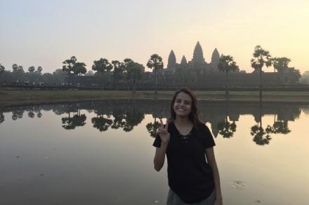 UMD student poses in front of a temple in Thailand.