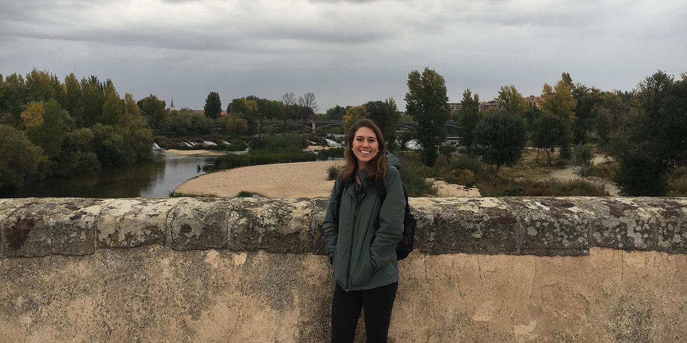 Kara Siglin in front of a stone wall and gray sky