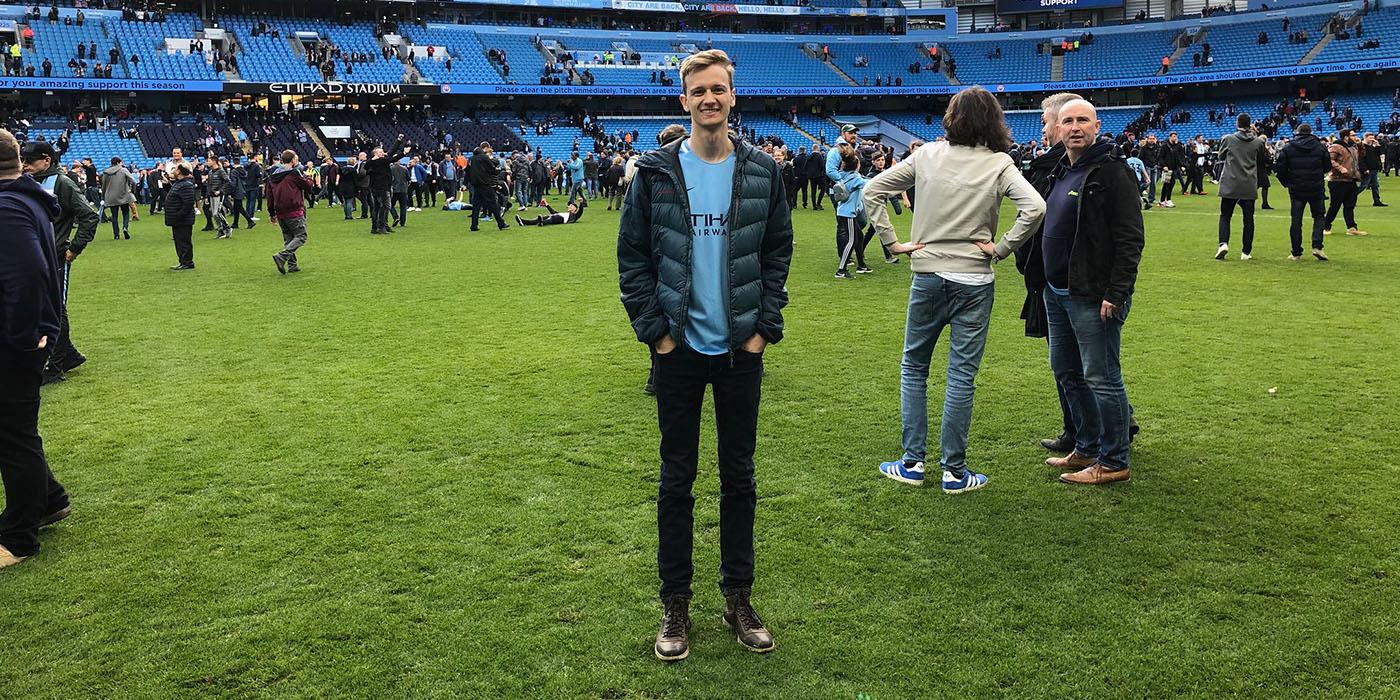 Liam standing on the pitch of the City of Manchester/Etihad Stadium