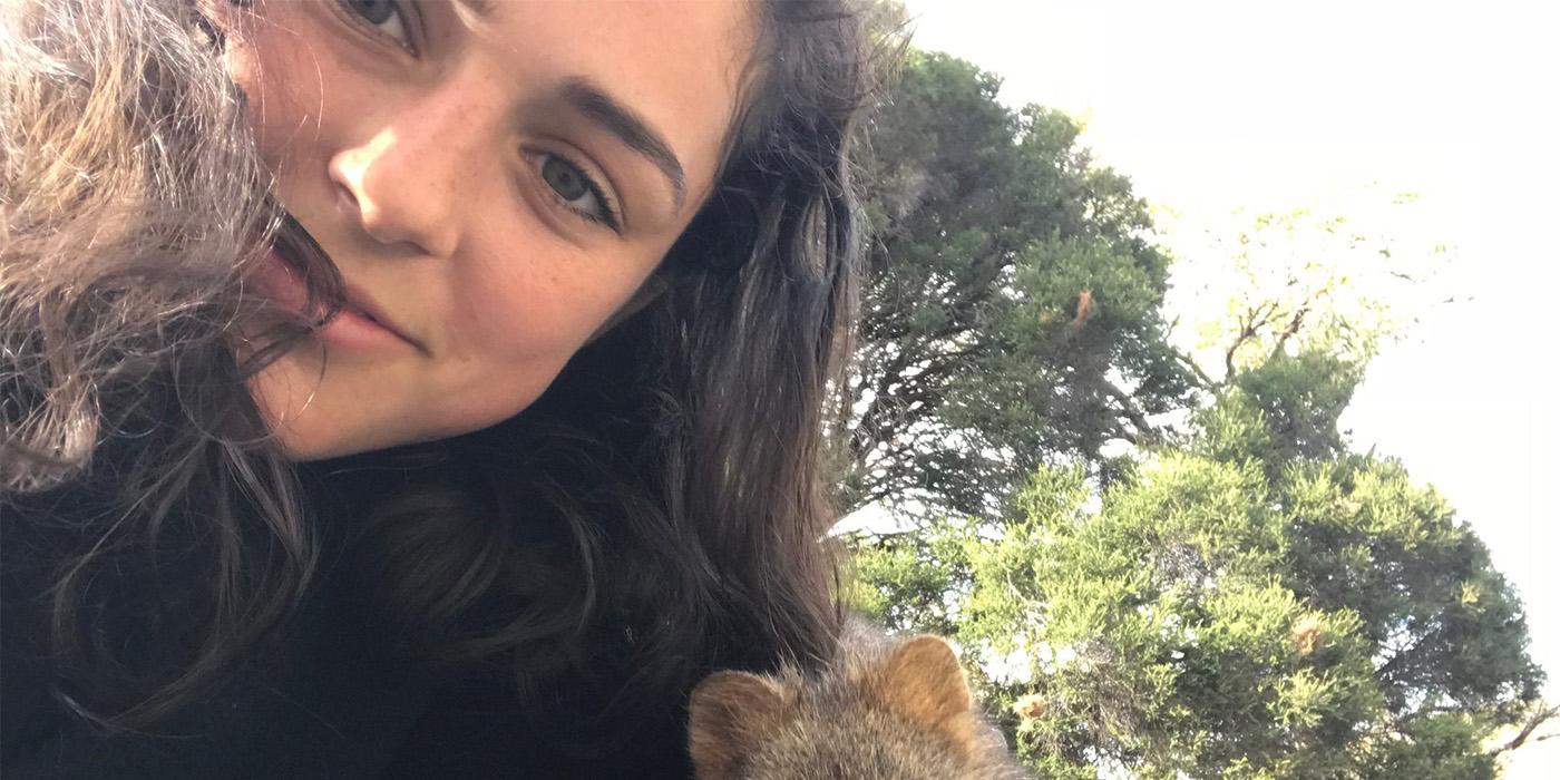 Margaret with her head close to a Quokka