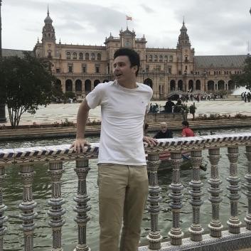 Student stands in front of a river in Madrid