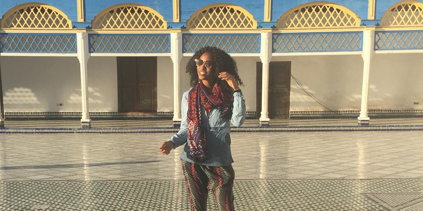 Nile Fossett wears a colorful scarf while standing in the Bahia Palace in Morocco