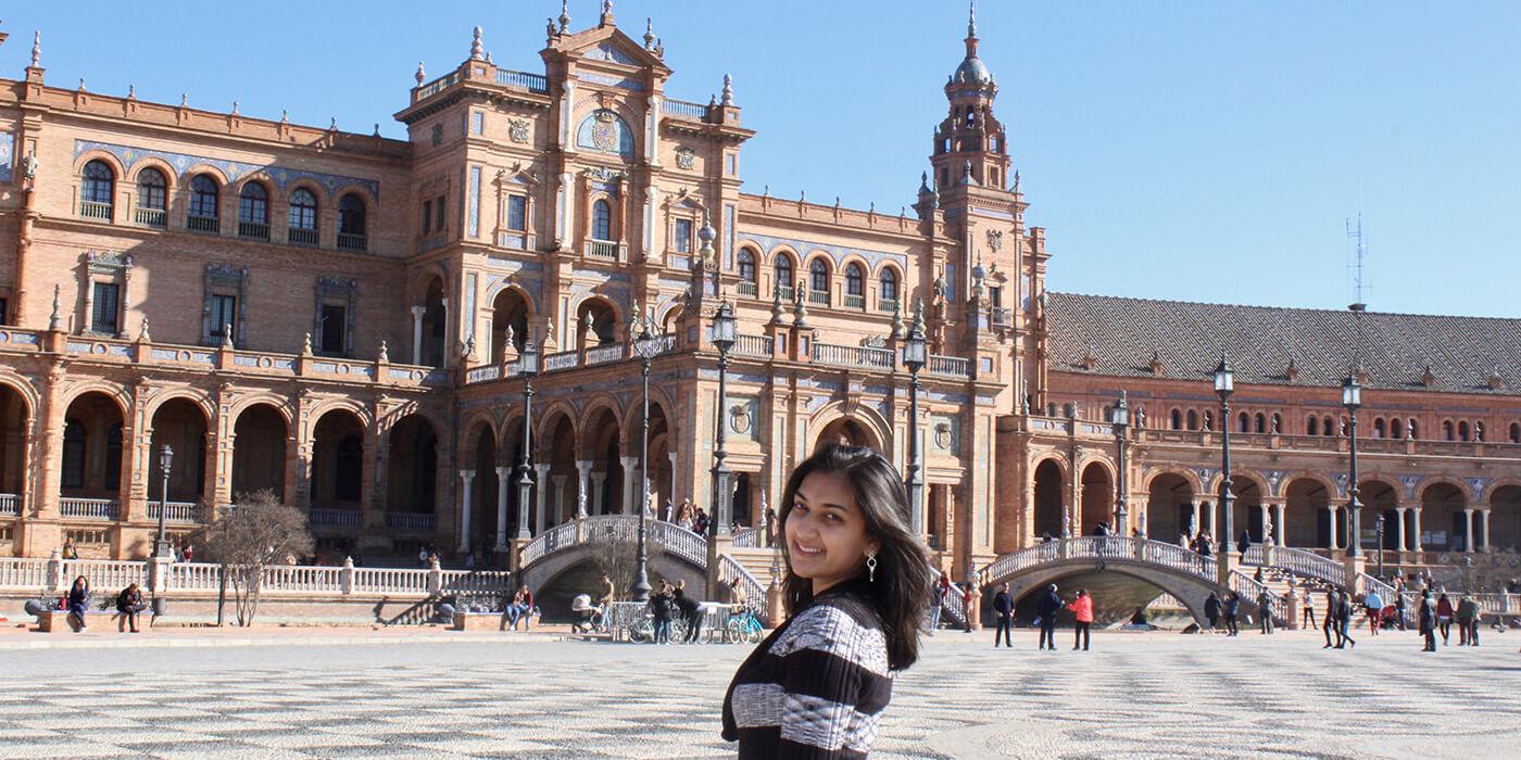 Radhika Gholap in front of a large ornate building