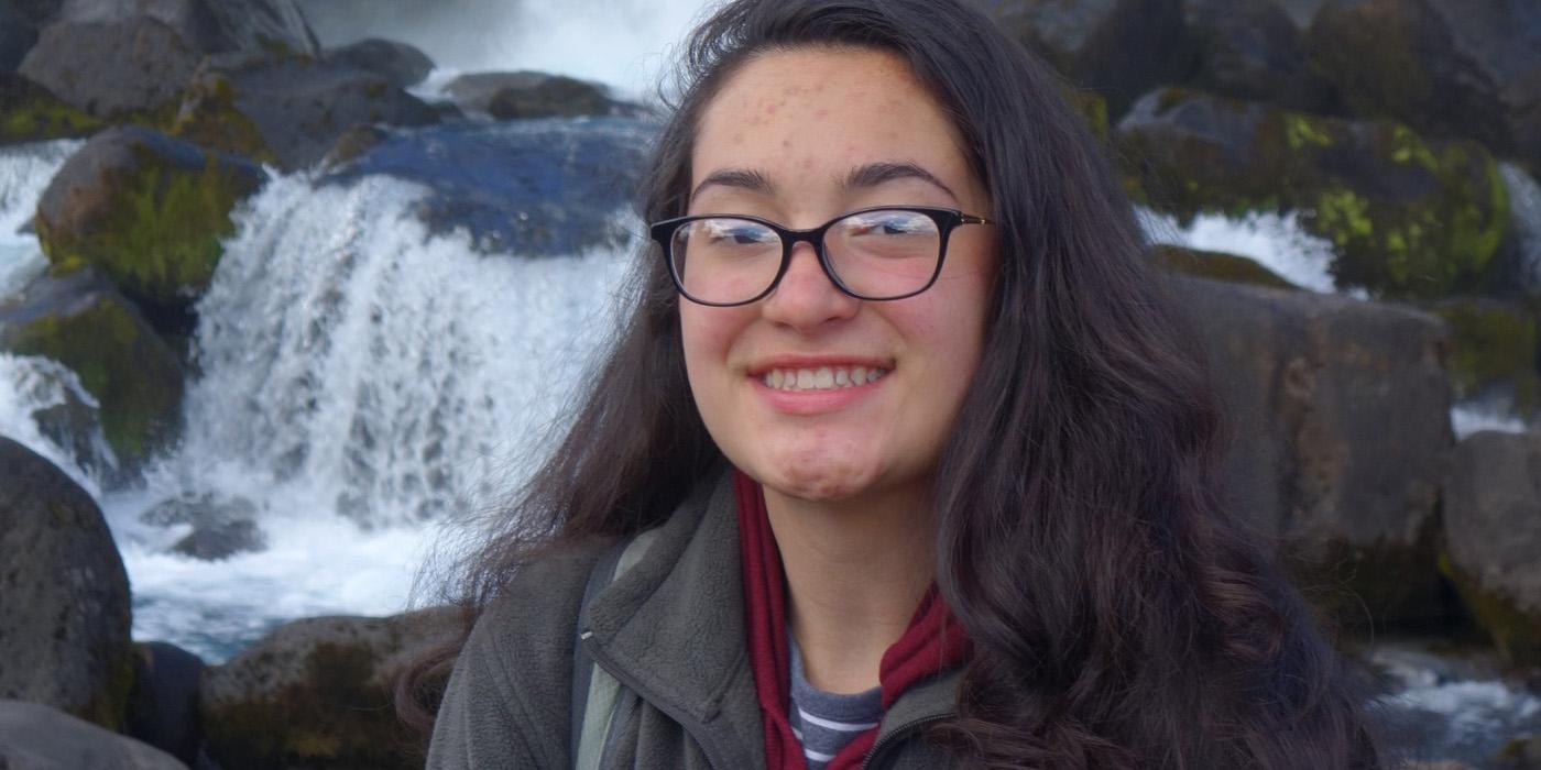 Sarah Pimentel stands in by a water fall in Iceland