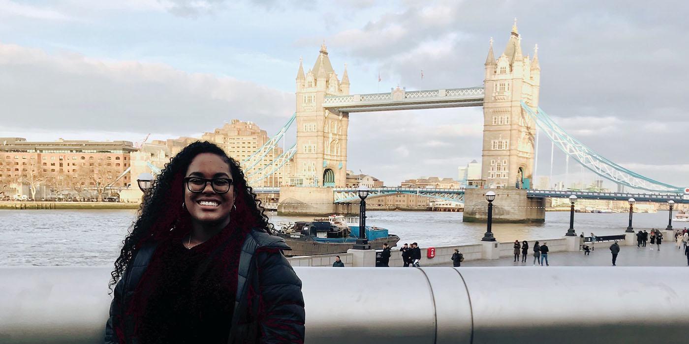 Serena standing and smiling with the Tower Bridge in the distance. 