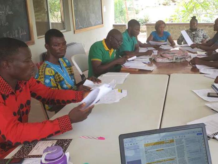 Several students at the Liberian Christian College working around a table.