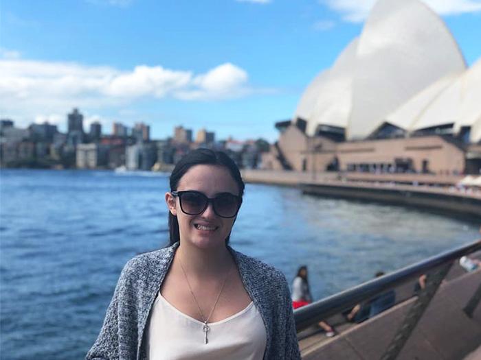 A UMD student smiling with the Sydney Opera House in the distance