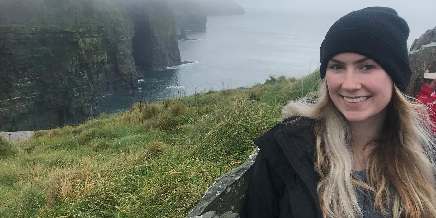 Zoe Zavrotny smiles in a foggy, grassy area in a rural town in Ireland