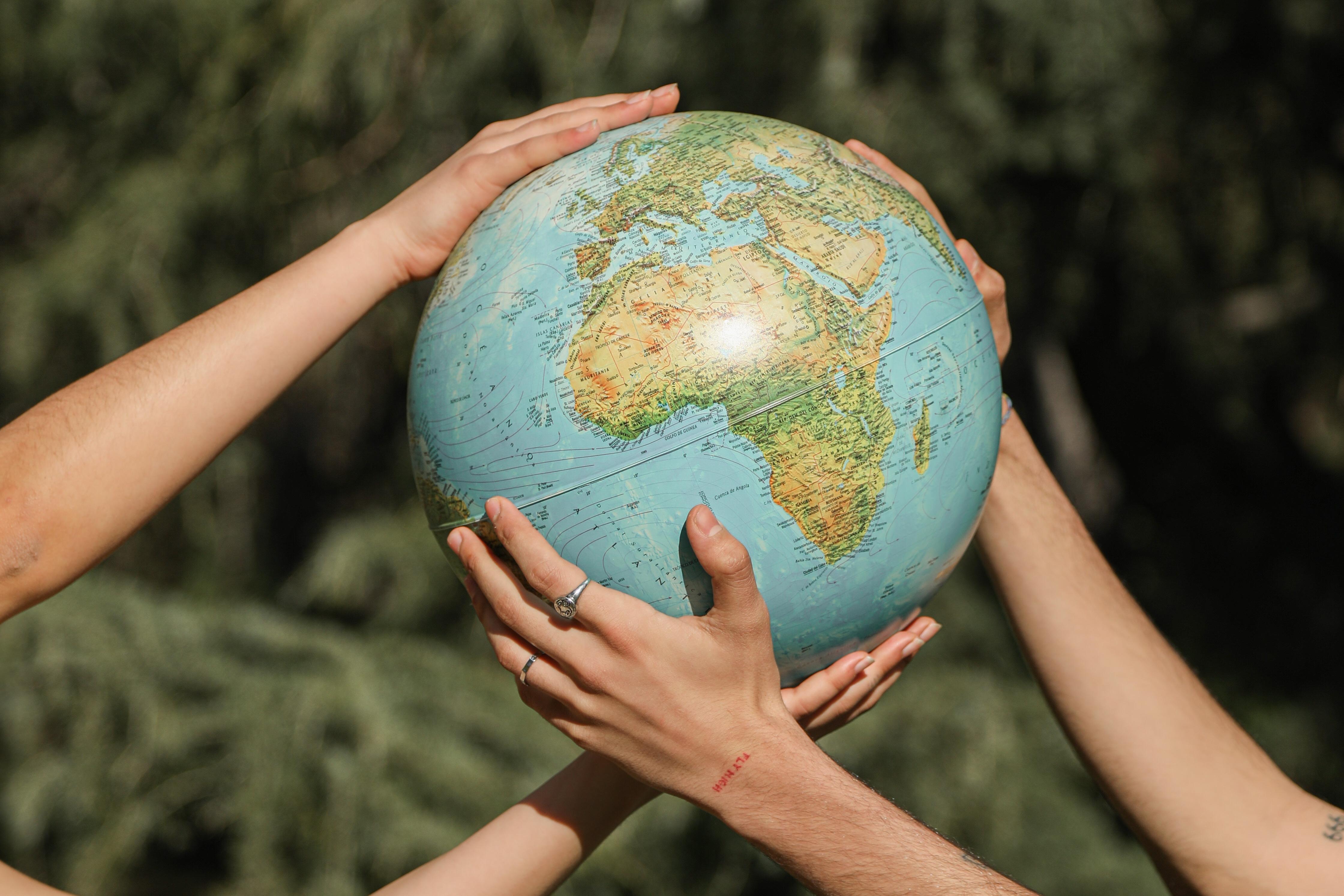 Pair of hands holding up a globe map.