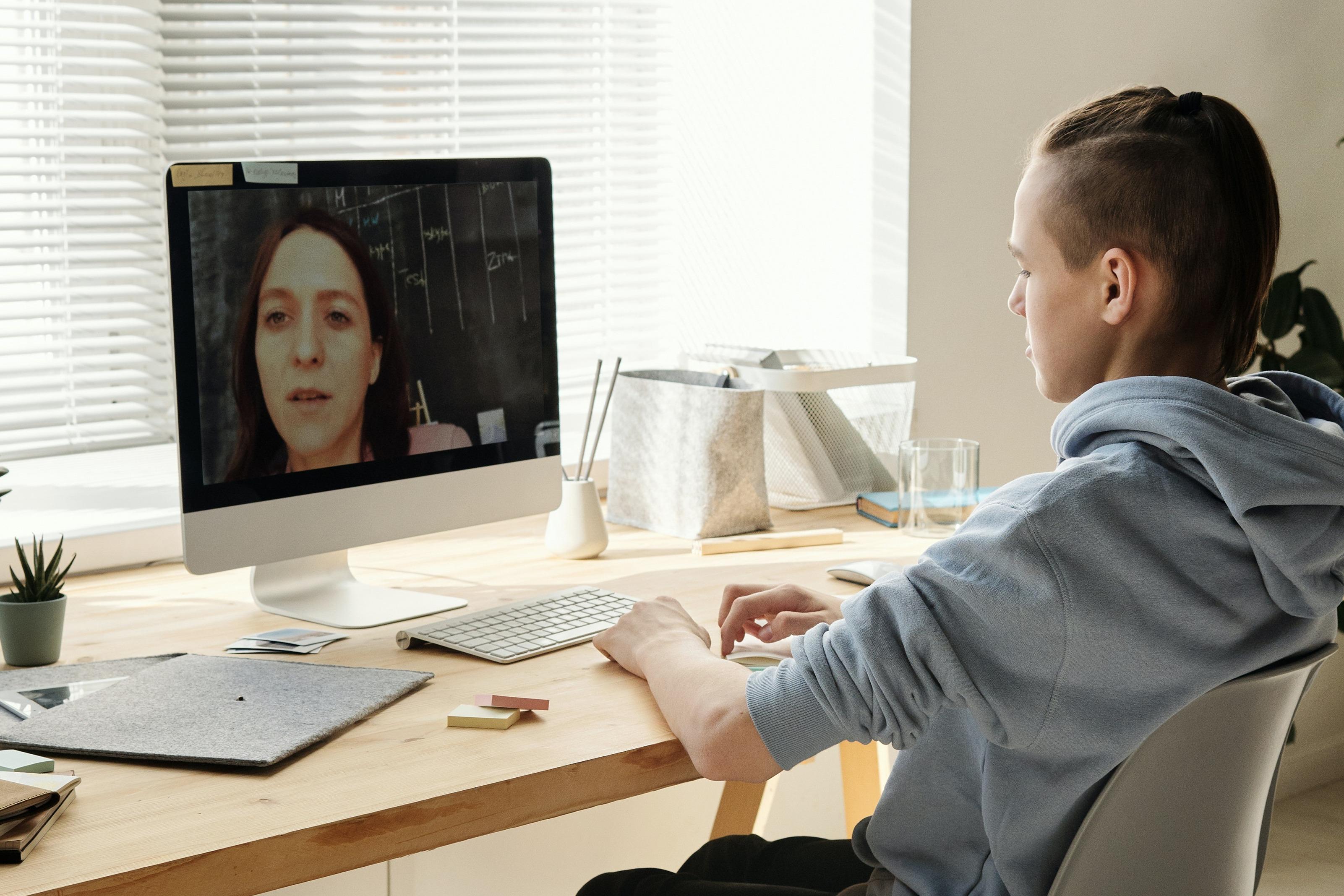 Boy looks at a video call on computer.