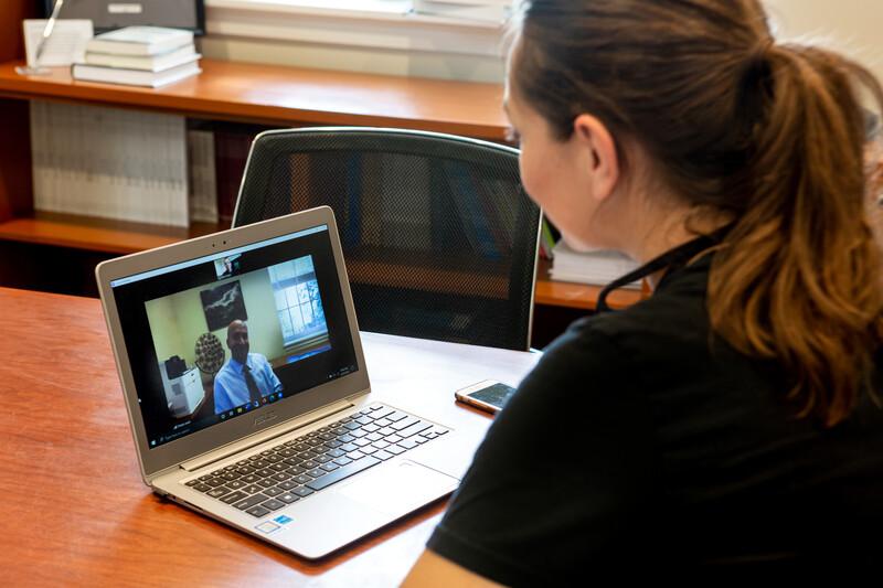 Two people interact through a zoom call during an online consultation session.
