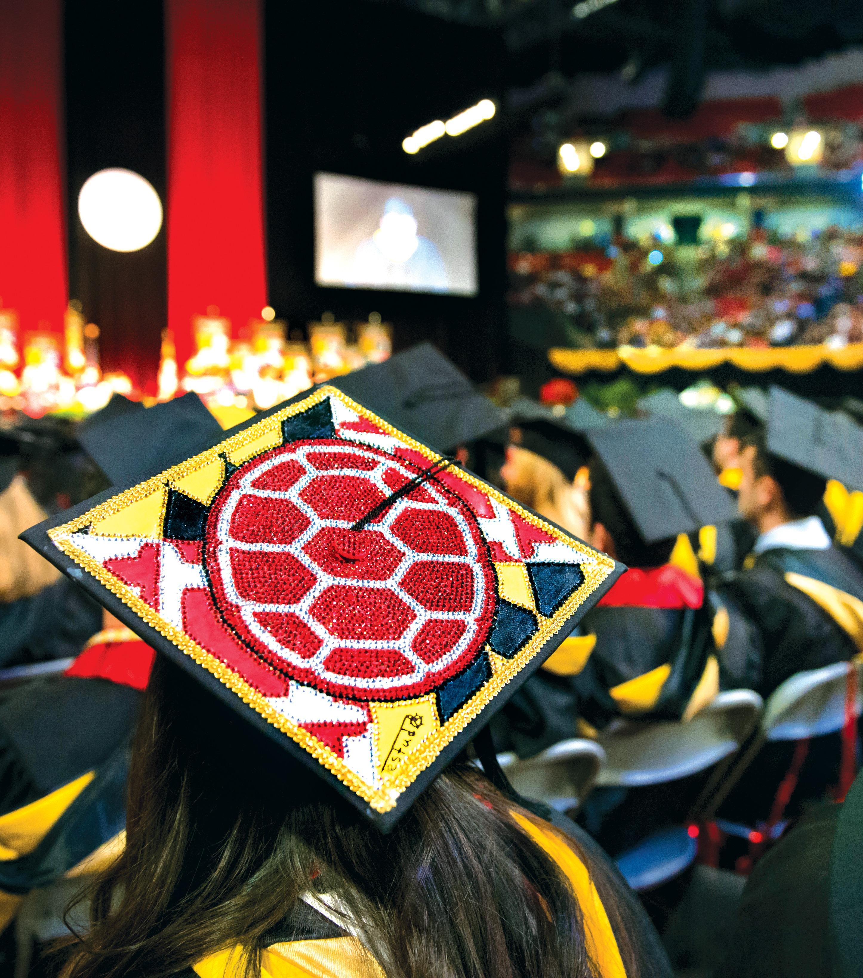 Students sit together at graduation.