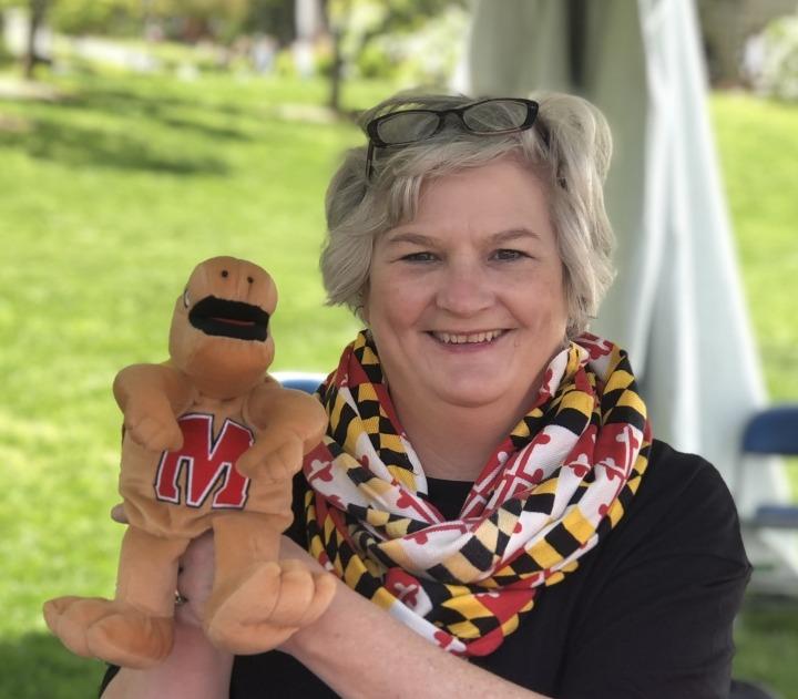 Jody Heckman-Bose poses with a stuffed animal Testudo.