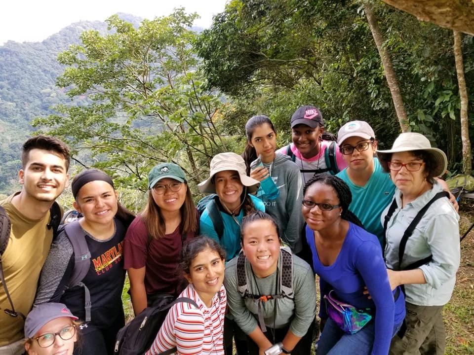 Students pose together in a group overlooking a valley.