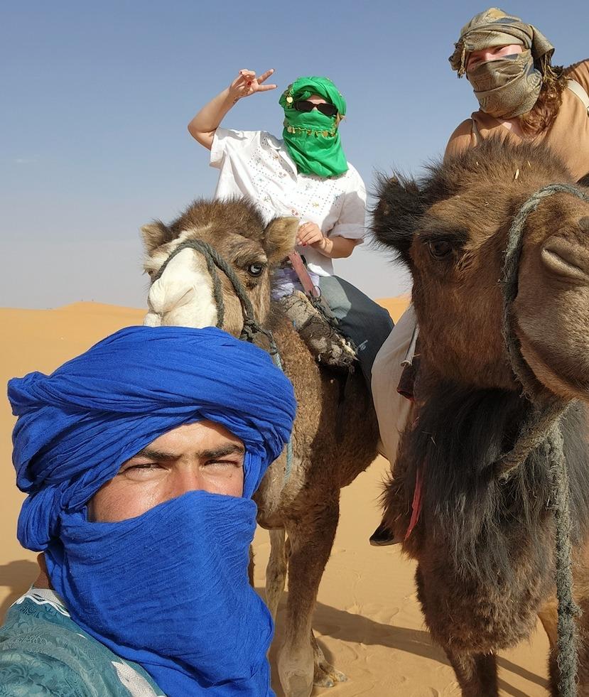 Students pose with camels. 