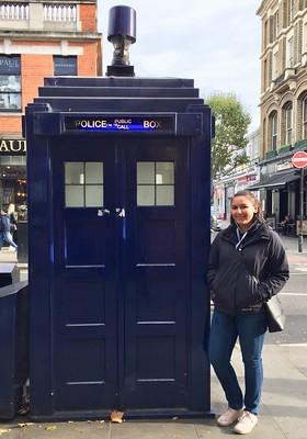 Study Abroad student next to police call box.