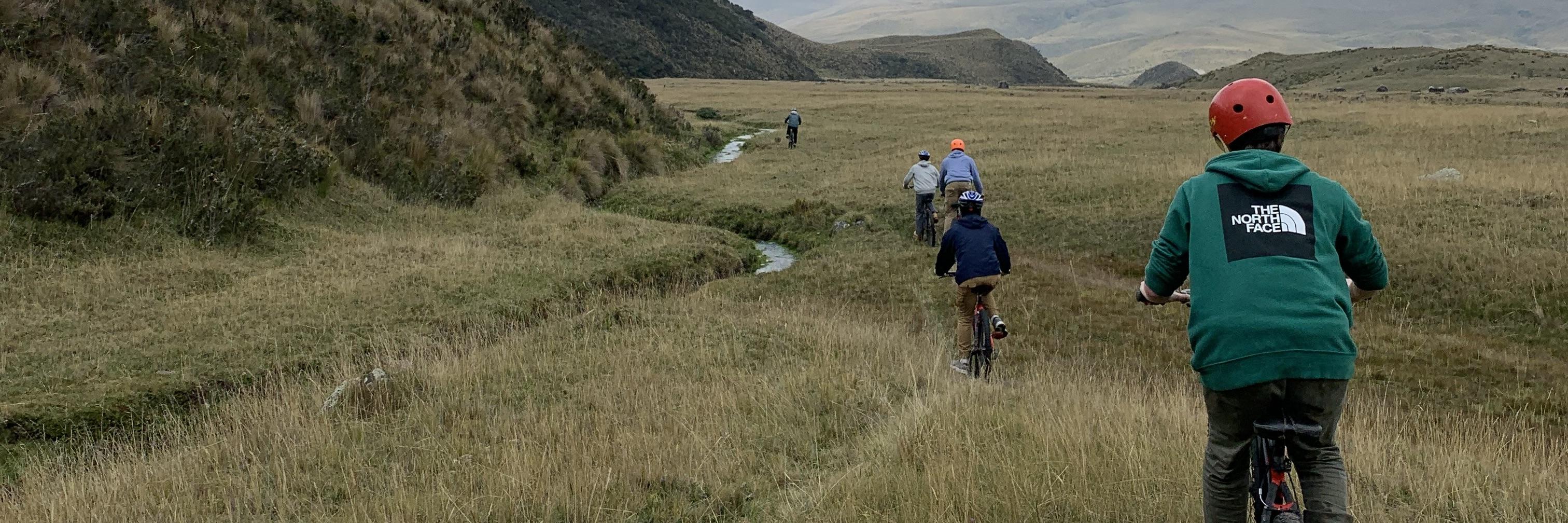 Student bike on a path through fields of rolling hills in Ecuador.