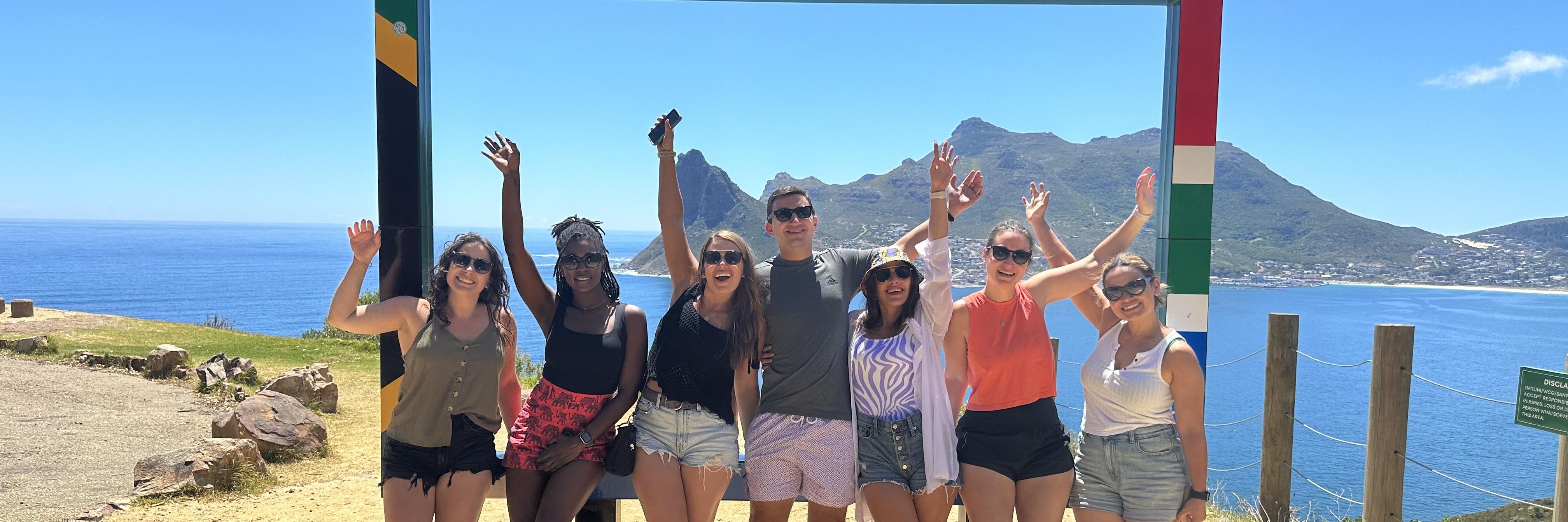 Seven students stand on an overlook by the water in Cape Town, South Africa