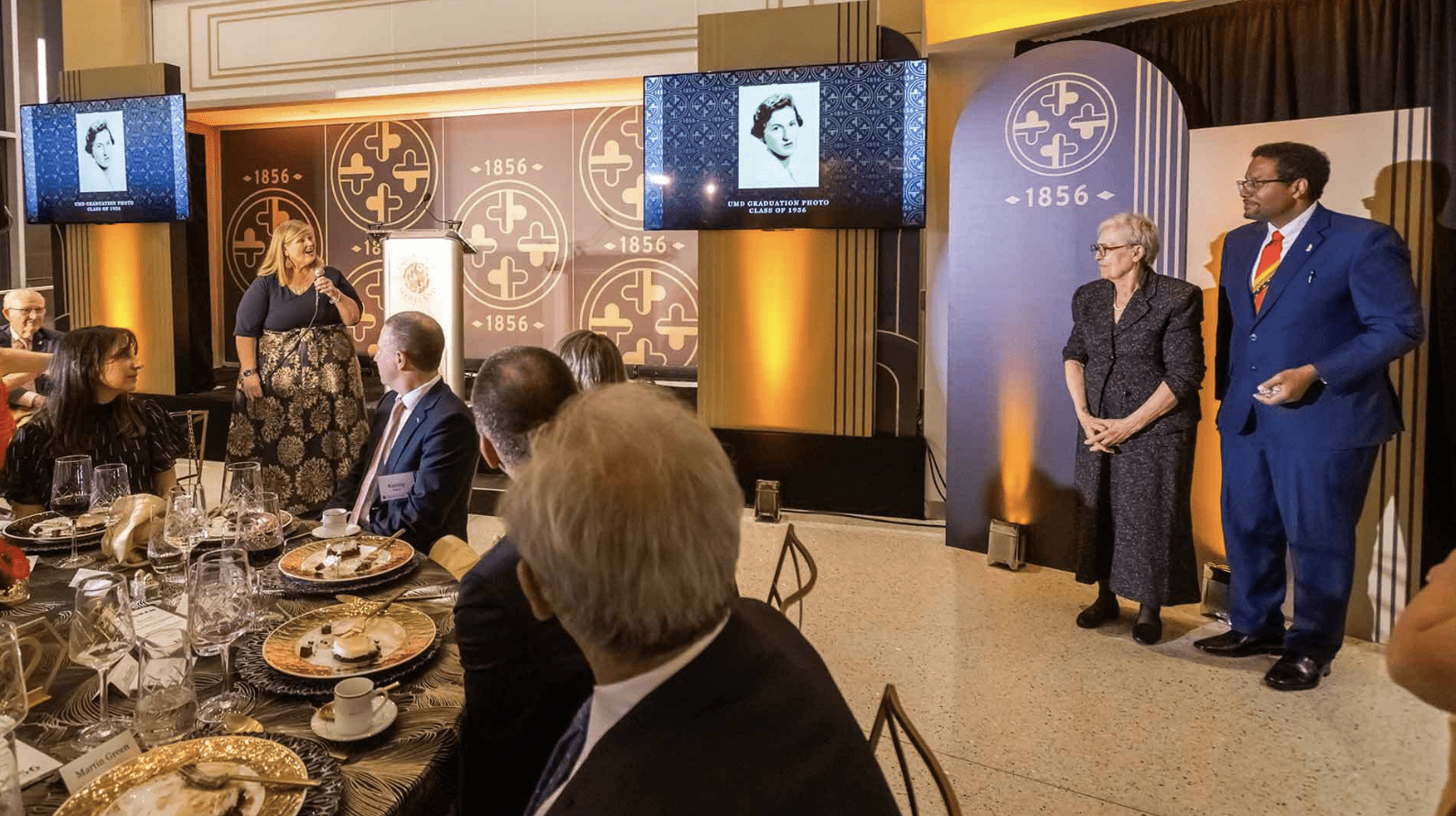 University leaders including Vice President for Student Affairs Patty Perillo (at left holding microphone) and President Darryll J. Pines (far right) honor Anna Karavangelos ’56 at an 1856 Society event last fall. A gift from Karavangelos established a new scholarship to support both documented and undocumented immigrants and children of immigrants.