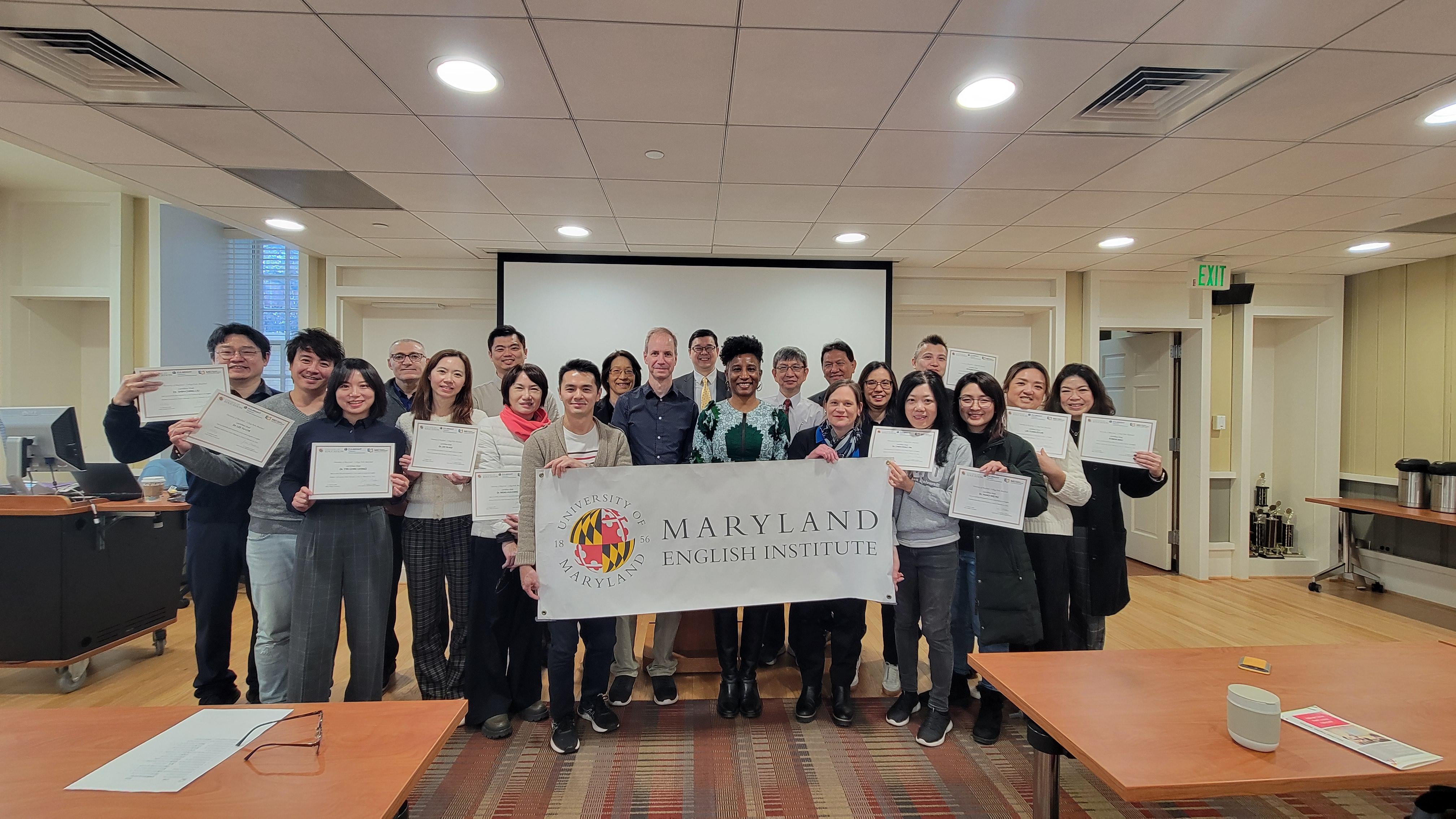 Taiwanese delegation group poses with dean holding a Maryland English Institute banner 