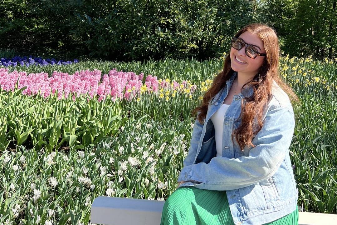 Charlie sits on a bench among Tulip fields