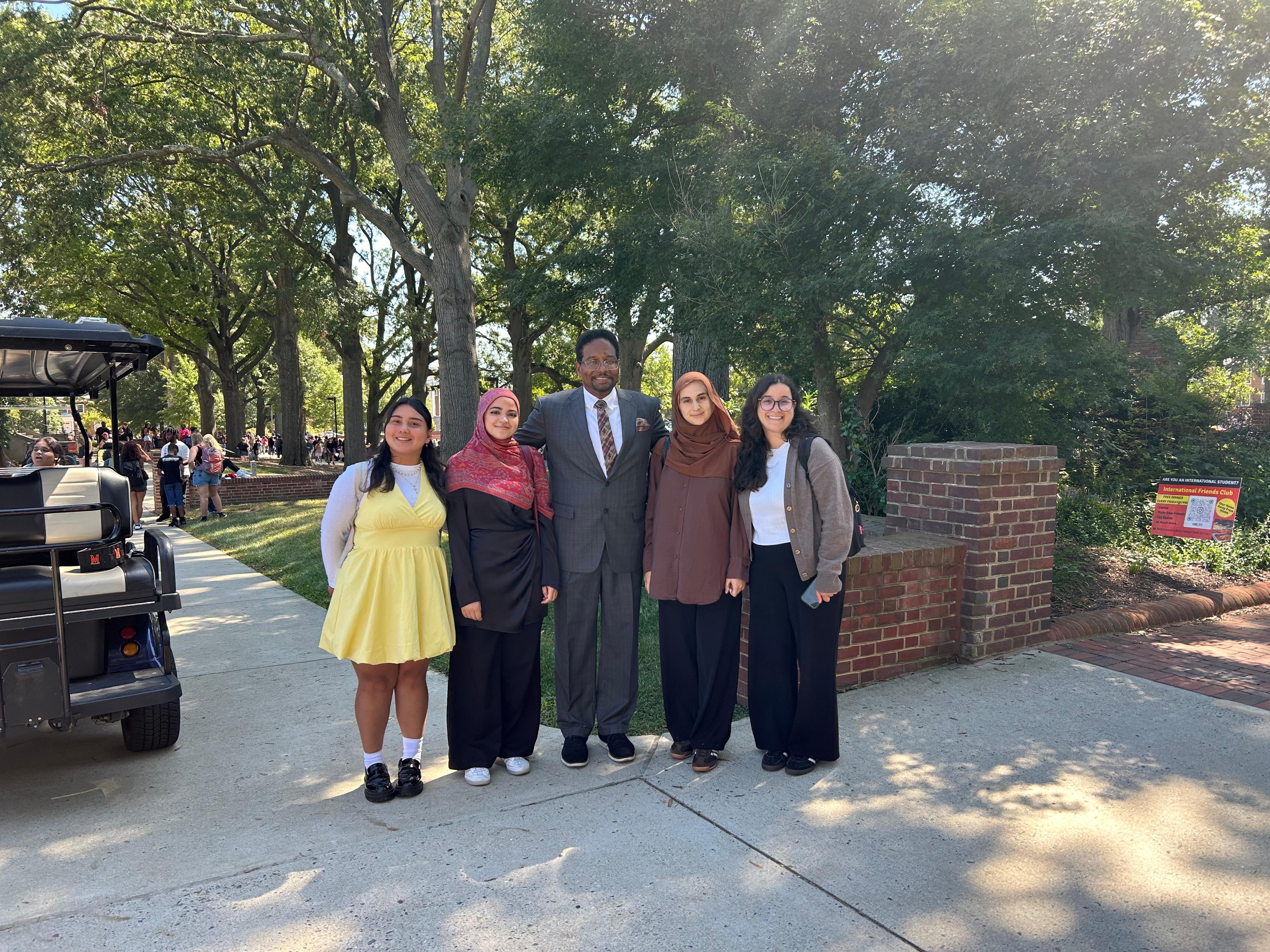 Four young women stand with President Pines