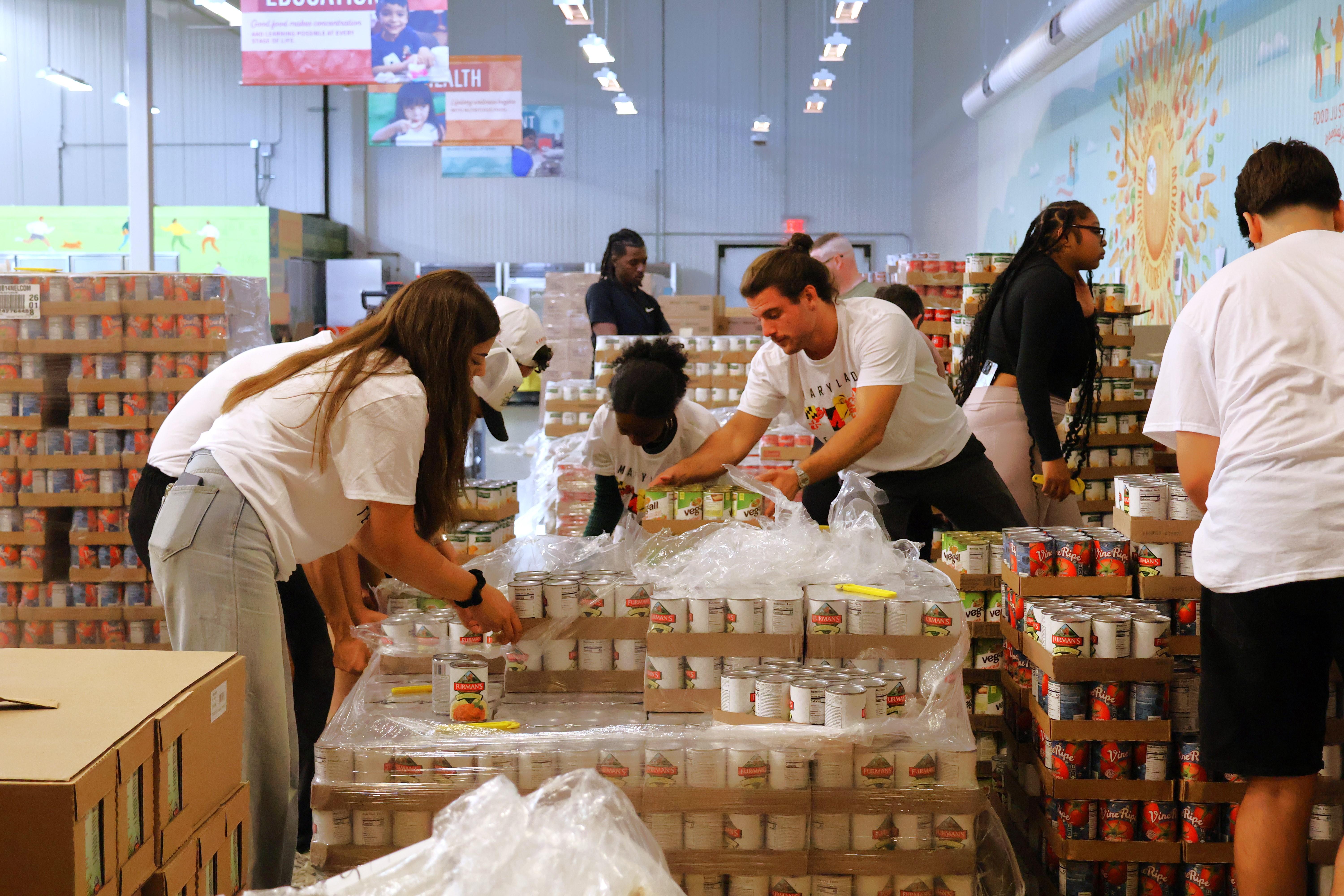 German students moving canned goods at a food bank