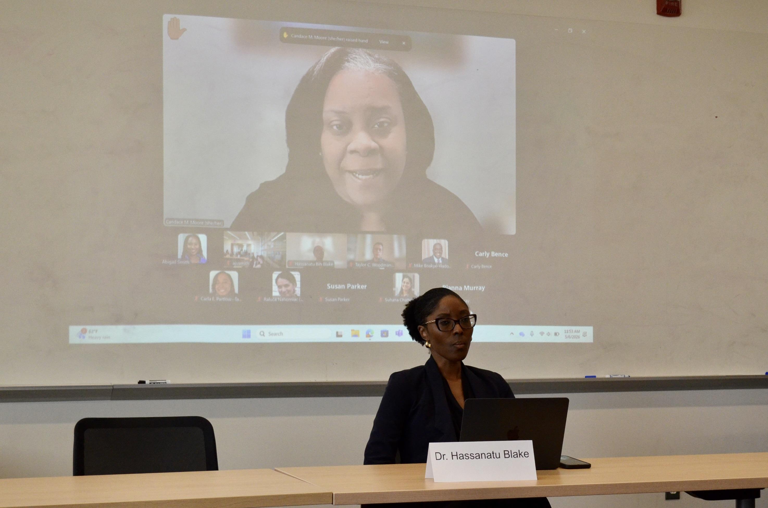 Dr. Blake sits in front of a screen as Dr. Moore asks a question via Zoom