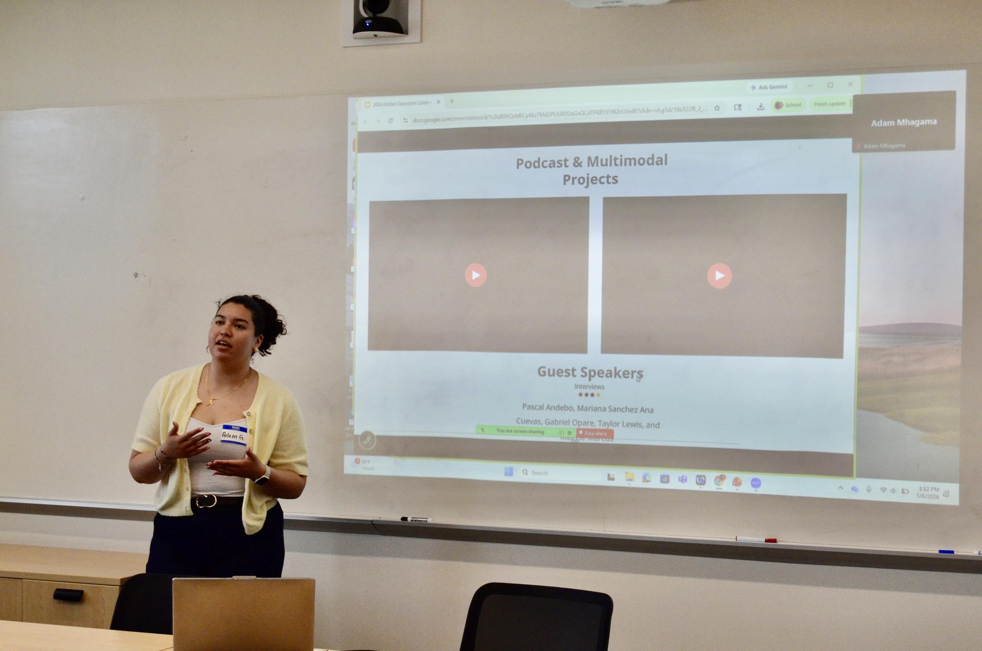 Student presents a slide deck in front of a small classroom